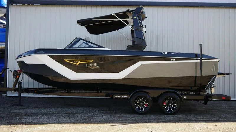 Slide: The Image of 2025 Nautique Super Air Nautique S23 boat on trailer, sleek design, black and white color scheme. - 3
