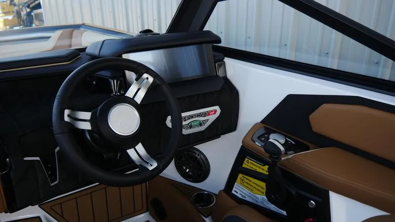 Slide: The Image of Interior of 2025 Nautique Super Air Nautique S23 boat, featuring steering wheel and control panel. - 5