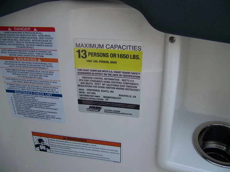 Slide: The Image of 2021 Chaparral 237 SSX capacity label, warning signs, and safety checklist on boat interior. - 10