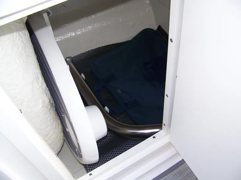 Slide: The Image of Storage compartment in 2021 Chaparral 237 SSX boat, featuring a folded table and bag. - 14