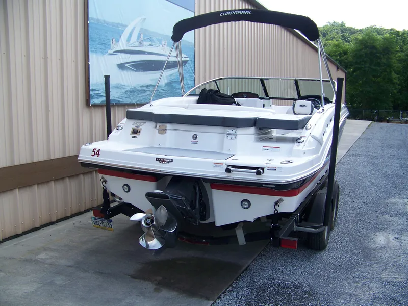 Slide: The Image of 2021 Chaparral 237 SSX boat on trailer, rear view, parked near a building. - 3