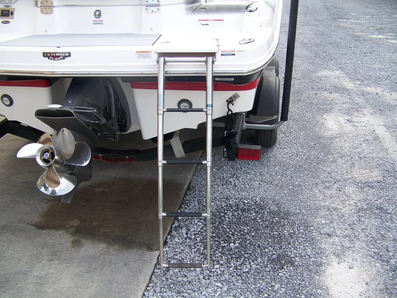 Slide: The Image of 2021 Chaparral 237 SSX boat stern with ladder and propeller on gravel surface. - 4