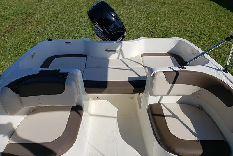 Slide: The Image of 2021 Bayliner Element E16 boat interior with cushioned seating on grass. - 7