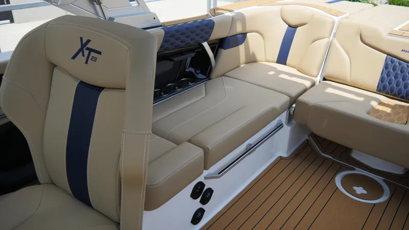 Slide: The Image of 2025 MasterCraft XT23 boat interior with tan and blue seating, showcasing luxury design. - 12