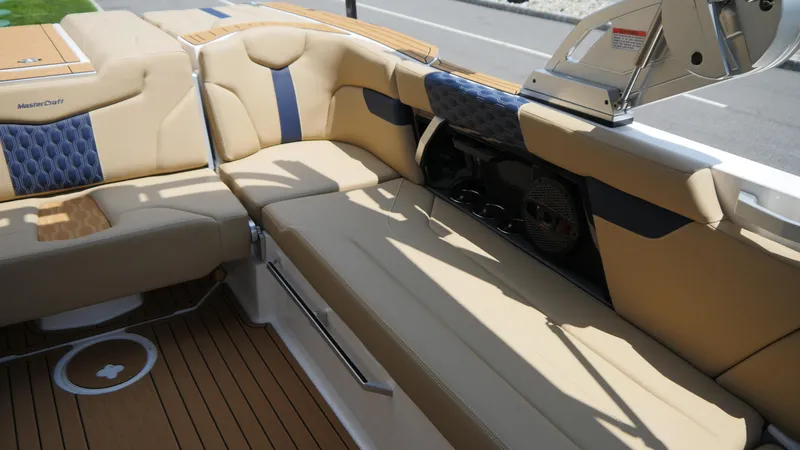 Slide: The Image of 2025 MasterCraft XT23 boat interior with tan and blue seating, showcasing luxury design. - 13