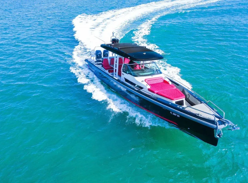 The Image of 2018 Axopar 37 Sun-Top boat cruising on blue water with red seating. - 0