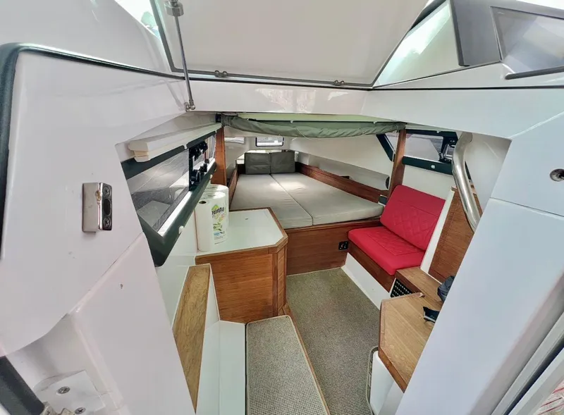 Slide: The Image of 2018 Axopar 37 Sun-Top cabin interior with seating and sleeping area. - 13