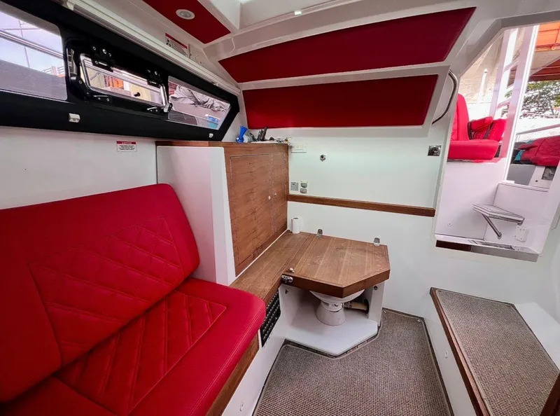 Slide: The Image of Interior of 2018 Axopar 37 Sun-Top with red seating and wooden accents. - 15