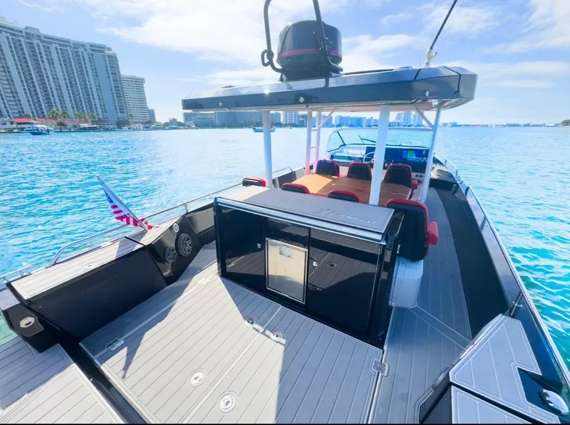 Slide: The Image of 2018 Axopar 37 Sun-Top boat on clear blue water, city skyline in background. - 4