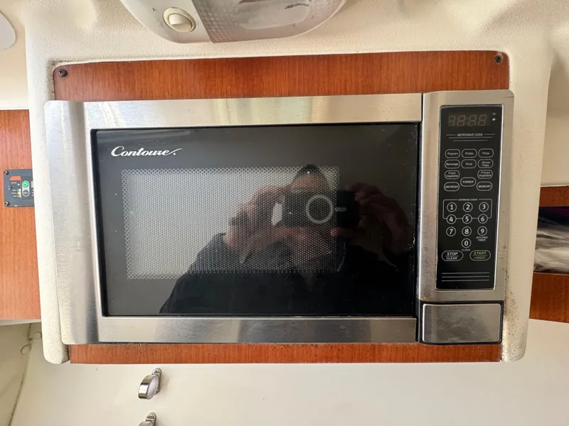 Slide: The Image of Microwave oven in 2014 Edgewater 280 CX boat interior, featuring digital controls. - 13