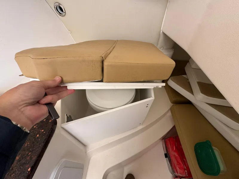 Slide: The Image of 2014 Edgewater 280 CX boat interior with hidden toilet under cushioned seat. - 14