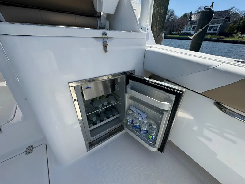 Slide: The Image of Open mini fridge on 2014 Edgewater 280 CX boat, stocked with water bottles. - 16