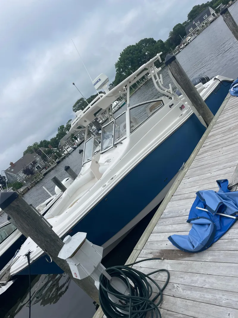 Slide: The Image of Edgewater 280 CX 2014 boat docked by a wooden pier on a cloudy day. - 4