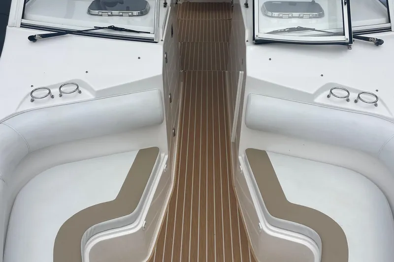 Slide: The Image of Interior view of a 2014 Edgewater 280 CX boat with cushioned seating and wood-patterned flooring. - 8