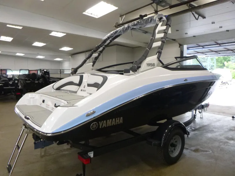 Slide: The Image of 2025 Yamaha Boats 195S in showroom, sleek design, black and white color scheme, on trailer. - 4