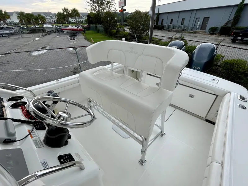 Slide: The Image of 2019 Regulator 23 boat interior with steering wheel and white seating, docked at marina. - 10