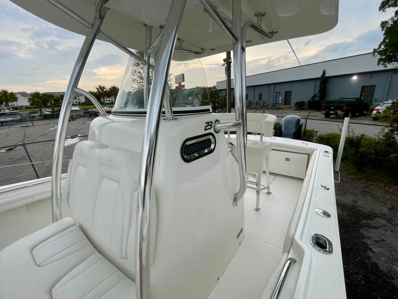 Slide: The Image of 2019 Regulator 23 boat interior with seating and chrome details, parked outdoors. - 11