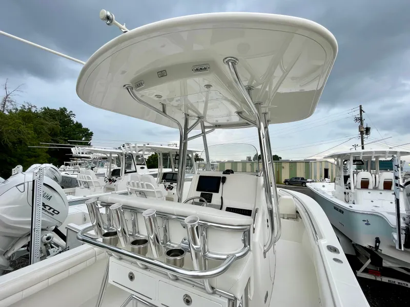 Slide: The Image of 2019 Regulator 23 boat with T-top and rod holders, displayed in a marina setting. - 12