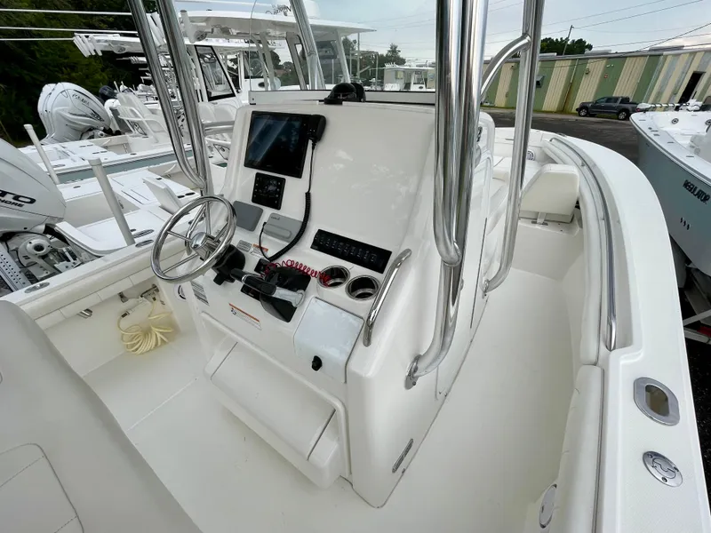 Slide: The Image of 2019 Regulator 23 boat console with steering wheel and navigation equipment. - 16