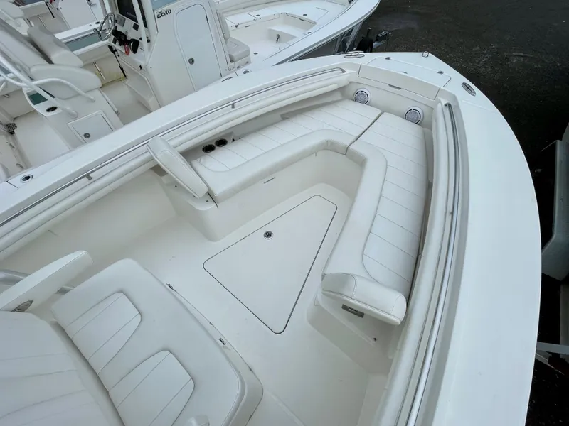 Slide: The Image of 2019 Regulator 23 boat interior with white cushioned seating and console. - 19