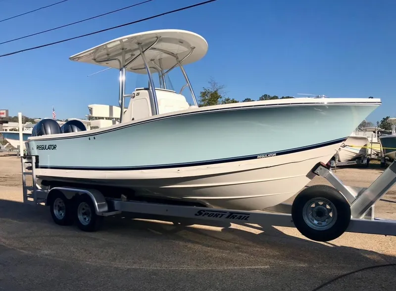 Slide: The Image of 2019 Regulator 23 boat on trailer, side view, clear blue sky background. - 3