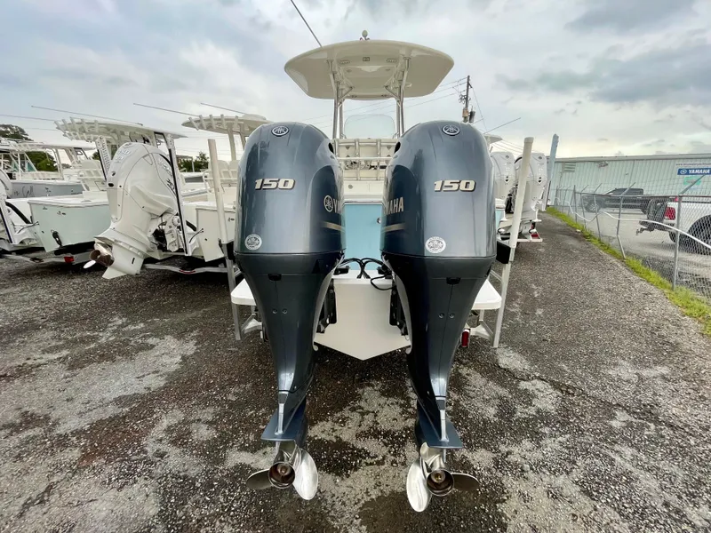 Slide: The Image of 2019 Regulator 23 boat with dual Yamaha 150 outboard engines, parked outdoors. - 5