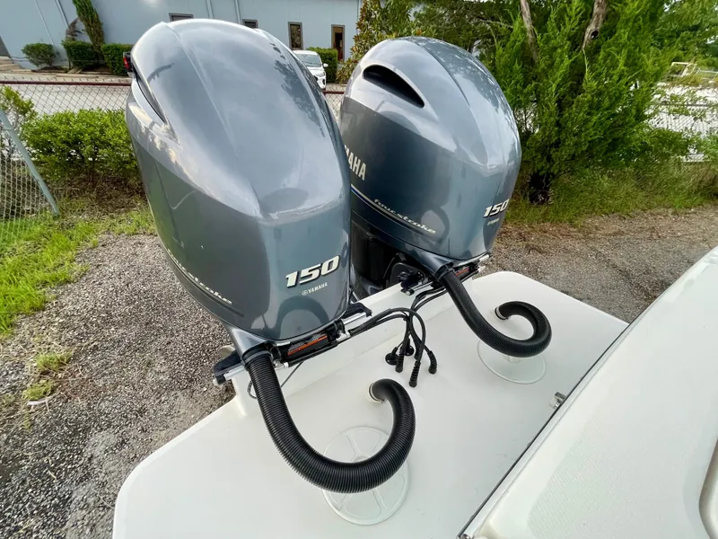 Slide: The Image of Twin Yamaha 150 outboard engines on a 2019 Regulator 23 boat, parked outdoors. - 7