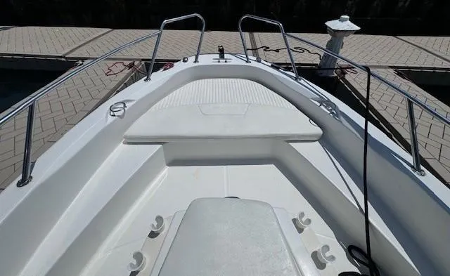 Slide: The Image of 2012 Boston Whaler 180 Dauntless boat deck with seating and railings at dock. - 10
