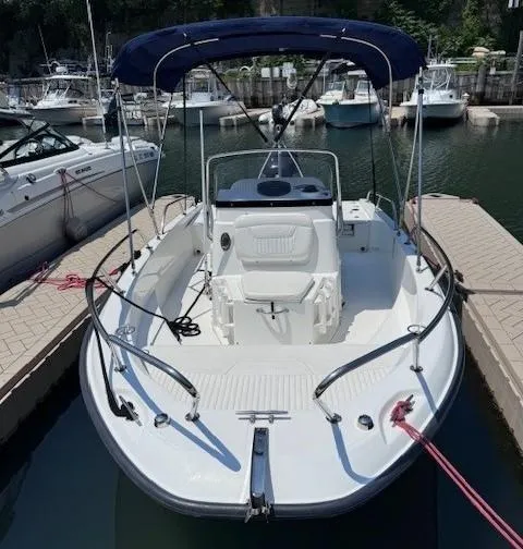 Slide: The Image of 2012 Boston Whaler 180 Dauntless boat docked in marina with canopy. - 12