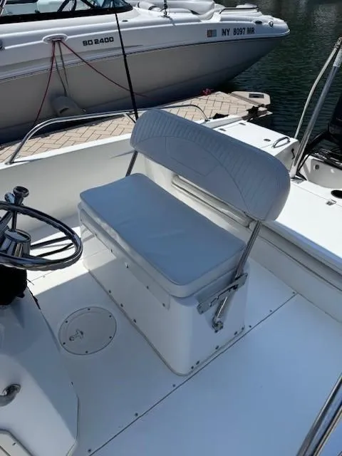 Slide: The Image of Boston Whaler 180 Dauntless 2012 boat interior with white cushioned seating and steering wheel. - 17