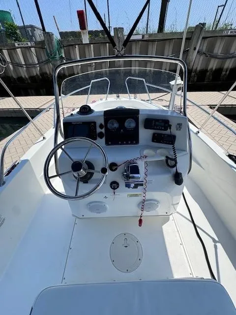 Slide: The Image of 2012 Boston Whaler 180 Dauntless boat console with steering wheel and navigation instruments. - 18