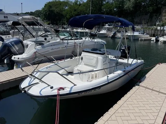 Slide: The Image of 2012 Boston Whaler 180 Dauntless boat docked at marina with blue canopy. - 19