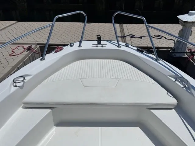 Slide: The Image of 2012 Boston Whaler 180 Dauntless boat bow with seating and railings, docked at a marina. - 9