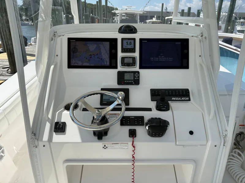 Slide: The Image of 2017 Regulator 34SS boat dashboard with navigation screens and steering wheel. - 15