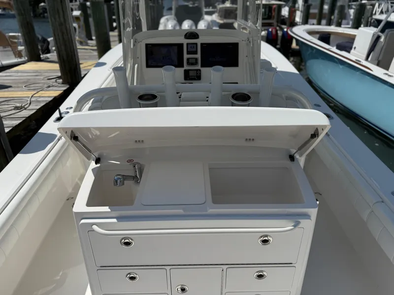 Slide: The Image of 2017 Regulator 34SS boat with sink, storage drawers, and rod holders at a marina. - 24