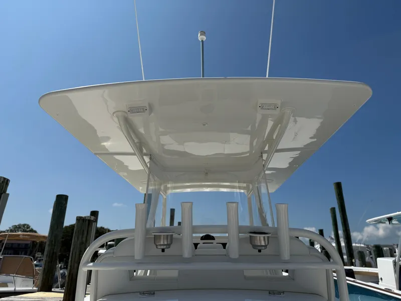 Slide: The Image of 2017 Regulator 34SS boat with T-top and rod holders, docked under clear blue sky. - 25