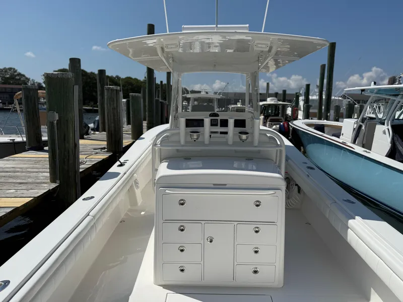 Slide: The Image of 2017 Regulator 34SS boat docked, featuring spacious deck and storage compartments. - 26