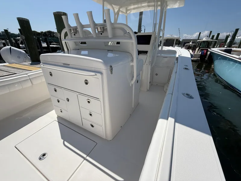 Slide: The Image of 2017 Regulator 34SS boat interior with storage compartments and rod holders at a marina. - 27