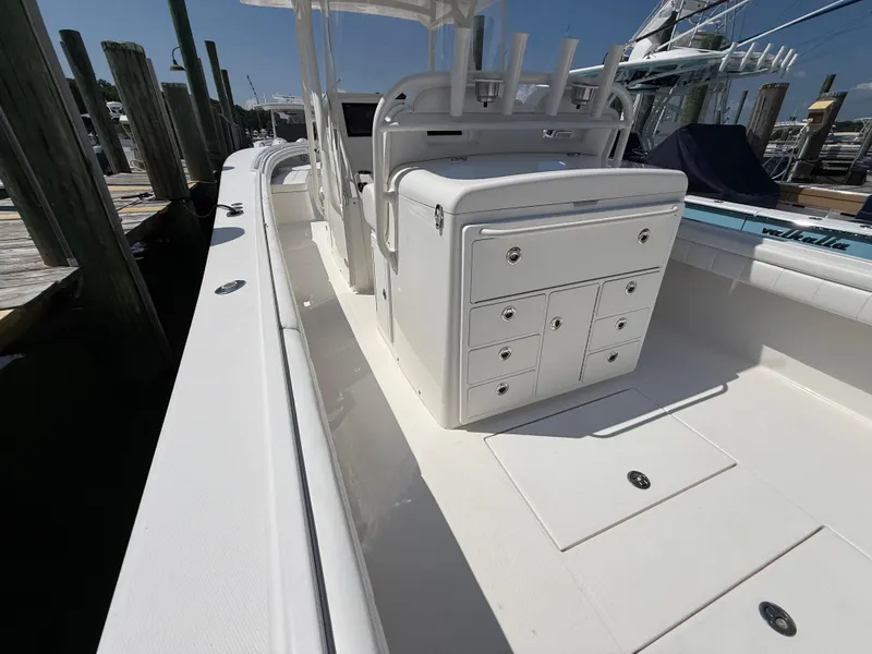 Slide: The Image of 2017 Regulator 34SS boat interior with storage compartments and rod holders at dock. - 28