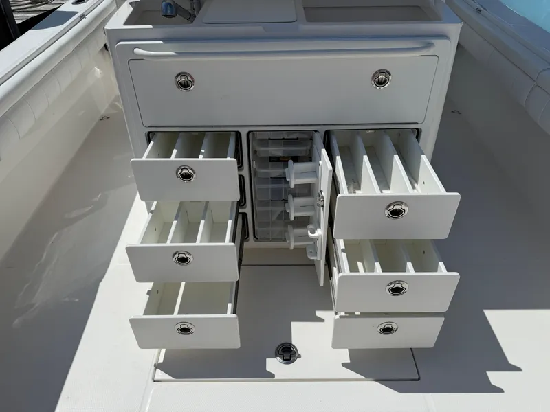 Slide: The Image of 2017 Regulator 34SS boat storage drawers open, showcasing organized compartments. - 29