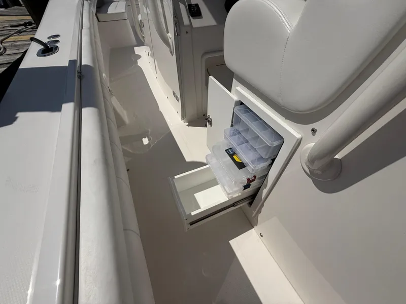 Slide: The Image of 2017 Regulator 34SS boat with open storage compartment and tackle boxes. - 32