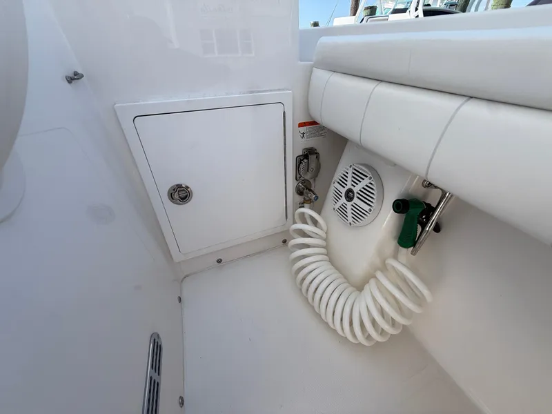 Slide: The Image of 2017 Regulator 34SS boat interior with storage compartment, speaker, and coiled hose. - 45