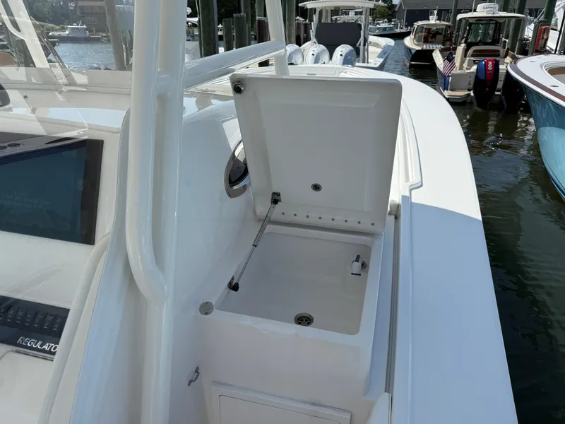 Slide: The Image of 2017 Regulator 34SS boat with open storage compartment at marina. - 46
