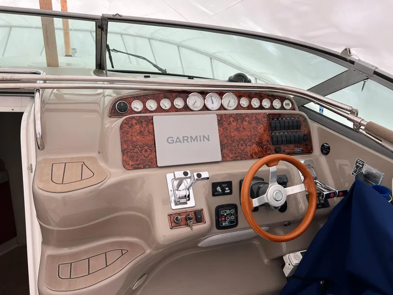 Slide: The Image of 2004 Wellcraft 3700 Martinique helm with Garmin navigation, wood accents, and modern controls. - 11