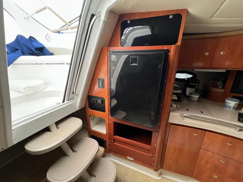 Slide: The Image of 2004 Wellcraft 3700 Martinique interior with wooden cabinetry and compact kitchen area. - 19