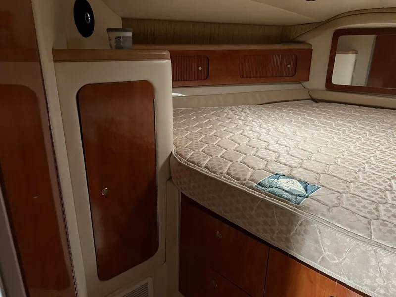 Slide: The Image of 2004 Wellcraft 3700 Martinique cabin interior with bed and wooden storage cabinets. - 22