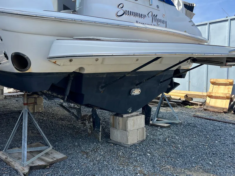Slide: The Image of 2004 Wellcraft 3700 Martinique boat on stands, undergoing maintenance in a gravel yard. - 4