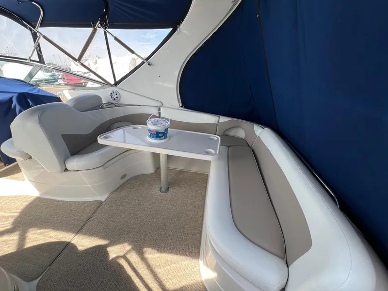 Slide: The Image of Interior seating area of 2004 Wellcraft 3700 Martinique boat with table and blue canopy. - 7