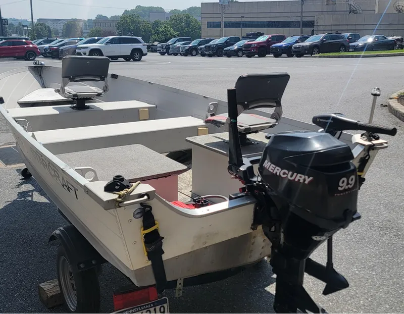 Slide: The Image of 2010 Starcraft SF 1415 boat with Mercury 9.9 motor in parking lot. - 4