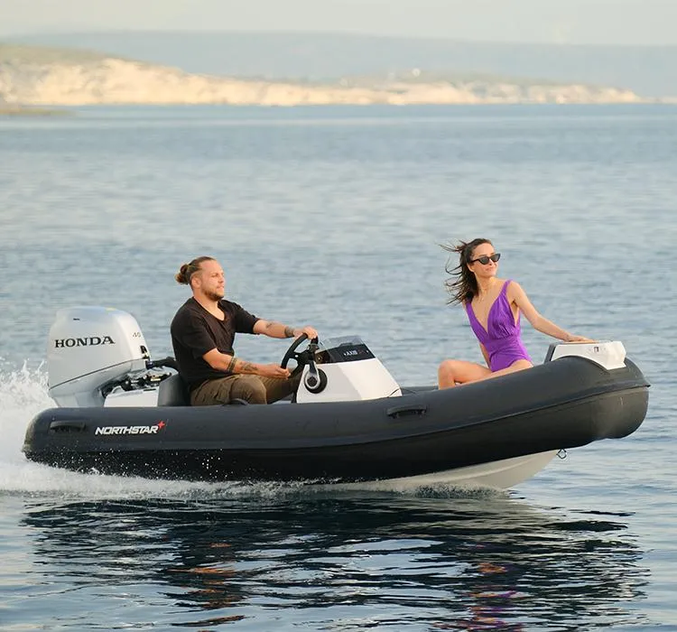 Slide: The Image of 2022 Northstar Axis 3.4 boat cruising with two passengers on a calm sea. - 11